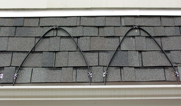 Self-regulating heat cable installed along roof eave.